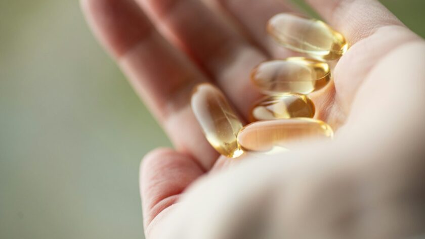 CoQ10 supplement capsules in hand